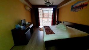 a bedroom with a large bed and a window at Guest House Bulevard in Drobeta-Turnu Severin