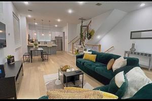 een woonkamer met een groene bank en een keuken bij Houston Downtown Homeaway in Houston