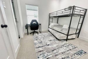een slaapkamer met een bed, een stoel en een bureau bij Houston Downtown Homeaway in Houston