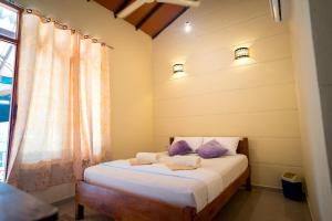 una camera da letto con un letto e due asciugamani di The Coastal Hotel a Trincomalee
