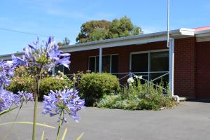 a brick building with purple flowers in front of it at Kermandie Hotel in Port Huon
