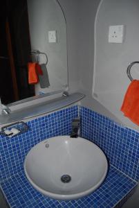 un bagno con lavandino bianco e bancone con piastrelle blu di The Coastal Hotel a Trincomalee