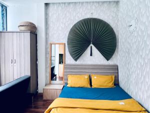 a bedroom with a bed with a clock on the wall at StudiO Le Thanh Ton R302 -Japanese Town- Saigon Central in Ho Chi Minh City