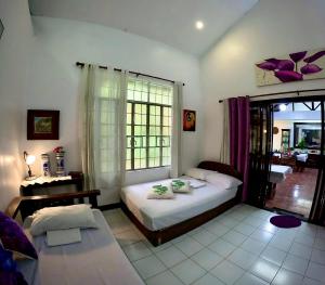 a bedroom with a bed and a table and a window at Auntie Gigi's Place in Tagaytay