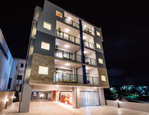 un edificio alto con luces encendidas por la noche en Zoe Resort The Sunset Village Okinawa Chatan, en Chatan