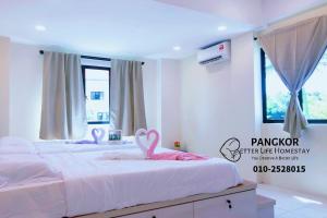 ein Schlafzimmer mit 2 Betten und rosa Schwänen darauf in der Unterkunft Better Life Apartment near beach-2room 2bathroom 6pax in Pulau Pangkor