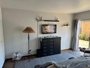 a living room with a black dresser and a lamp at 5 Bayview Gonubie Seafront in Gonubie