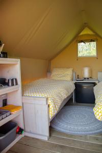 a bedroom with a bed and a sink in a tent at Safaritent Lodge 2 (2 persoons) in Ruurlo
