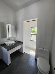 un bagno con un water bianco e un lavandino di Luxurious Ocean View Villa a Cozumel