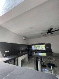 una cucina con ventilatore a soffitto, tavoli e sedie di Luxurious Ocean View Villa a Cozumel
