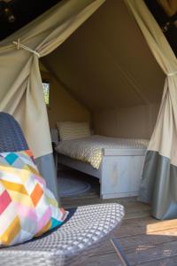 a tent with two beds and a chair in it at Safaritent Lodge 2 (2 persoons) in Ruurlo