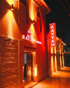 a restaurant with neon signs on the side of a building at Rayyan Hotel Bukhara in Bukhara