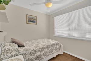 a white bedroom with a bed and a window at Como Executive Apartment in Perth