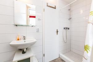 ein weißes Bad mit einem Waschbecken und einer Dusche in der Unterkunft cozy Apartments in Mülheim in Köln