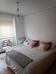 1 cama blanca grande en una habitación con ventana en Apartamento con terraza en Comillas