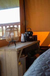 einen Tisch mit Kaffeemaschine und Korb darauf in der Unterkunft Safaritent Lodge 2 plus in Ruurlo