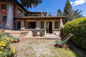 a house with two lawn chairs in front of it at Fattoria la Gigliola - La Limonaia in Montespertoli
