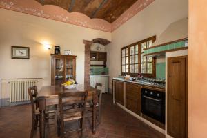 a kitchen with a table and some chairs in it at Fattoria la Gigliola - La Limonaia in Montespertoli