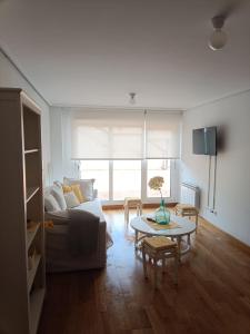 een woonkamer met een bank en een tafel bij Apartamento con terraza in Comillas