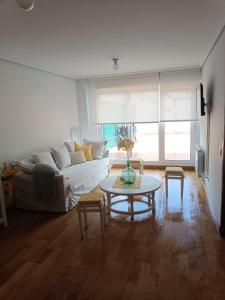 a living room with a couch and a table at Apartamento con terraza in Comillas