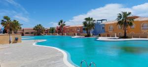 einen Pool in einem Resort mit Palmen und Häusern in der Unterkunft Casita del Sol - duplex with Sea View and community Pool on the Cumbre del Sol in Benitatxell