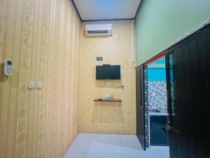 a bathroom with a tv on the wall at RedDoorz Syariah near Sunrise Mall Mojokerto in Mojokerto