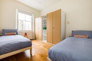 a bedroom with two beds and a closet at Stunning Notting Hill APT, Beautiful Street in London