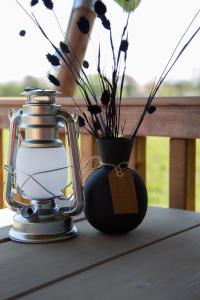 a vase with a tag on it next to a lantern at Safaritent Lodge 2 plus in Ruurlo