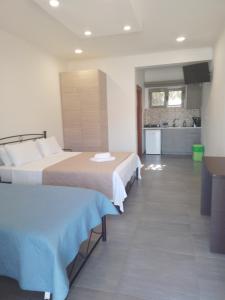um quarto de hotel com duas camas e uma cozinha em Agia Kiriaki Bungalows em Alikanas