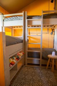 Zimmer mit Etagenbett, 2 Etagenbetten und einem Tisch in der Unterkunft Safaritent Lodge 5 in Ruurlo