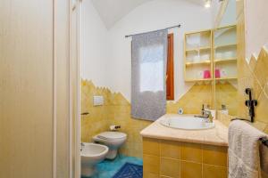 a bathroom with a sink and a toilet and a mirror at Casa Relax Vista mozzafiato in Cannigione +22 photos