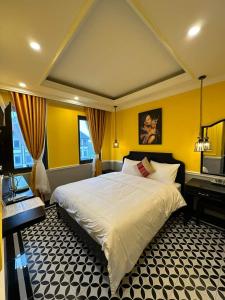 a bedroom with a large white bed and a piano at Sapa Tay Bac Home in Sa Pa