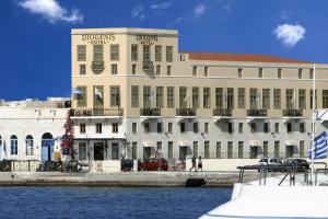 ein großes Gebäude neben einem Wasserkörper in der Unterkunft Diogenis Hotel in Ermoupoli