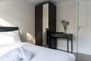 a bedroom with a bed and a table with a mirror at Dunkirk House in Southampton