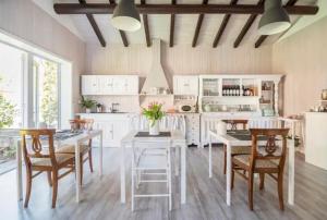 a kitchen with white cabinets and a table and chairs at B&B La Dolce Casa Lago di Como in Cremia