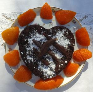 a heart shaped chocolate cake on a plate with oranges at Les Pierres Lotoises - chambre dhôtes Le Pigeonnier in Reilhaguet