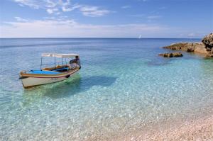 a man sitting on a boat in the water at Sea & Sun 4* in Banjole