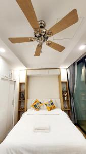 a bedroom with a ceiling fan and a bed with pillows at Studio Lake view Vinhomes Greenbay #Jerry's House in Hanoi