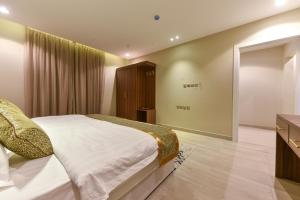 um quarto com uma cama grande e uma televisão em شقق الهدوء Alhudu Apartments em Riade