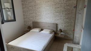 a bed in a room with a brick wall at Poseidon room's Vourvourou in Vourvourou