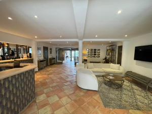 ein großes Wohnzimmer mit einem Sofa und einem Tisch in der Unterkunft La Villa Dune, Hôtel & Spa Nuxe in Saint-Tropez