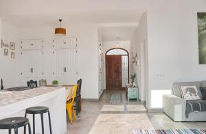 cocina y sala de estar con mesa y sillas en Casa Aqua, en El Guijo