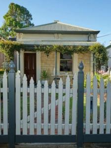 ein weißer Gartenzaun vor einem Haus in der Unterkunft Short Walk to The Parade and Norwood Oval in Kensington and Norwood