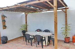 a patio with a table and chairs under a pergola at Casa Aqua in El Guijo