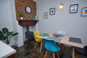 ein Esszimmer mit Tisch und Stühlen und einem Kamin in der Unterkunft Short Walk to The Parade and Norwood Oval in Kensington and Norwood