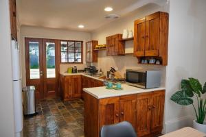 eine Küche mit Holzschränken und einer Arbeitsplatte in der Unterkunft Short Walk to The Parade and Norwood Oval in Kensington and Norwood + 10 Fotos