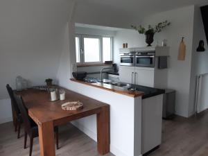uma cozinha com uma mesa de madeira e uma bancada em BenB Humblebee em Alkmaar