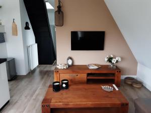 uma sala de estar com uma mesa de madeira e uma televisão em BenB Humblebee em Alkmaar