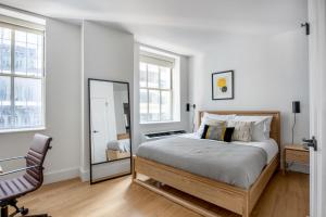 a bedroom with a bed and a mirror and a chair at FiDi 2BR w Gym Lounge Complete Gym NYC-497 in New York