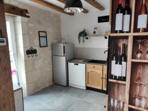 cocina con nevera y barra con botellas de vino en Maison de charme en Ligueil